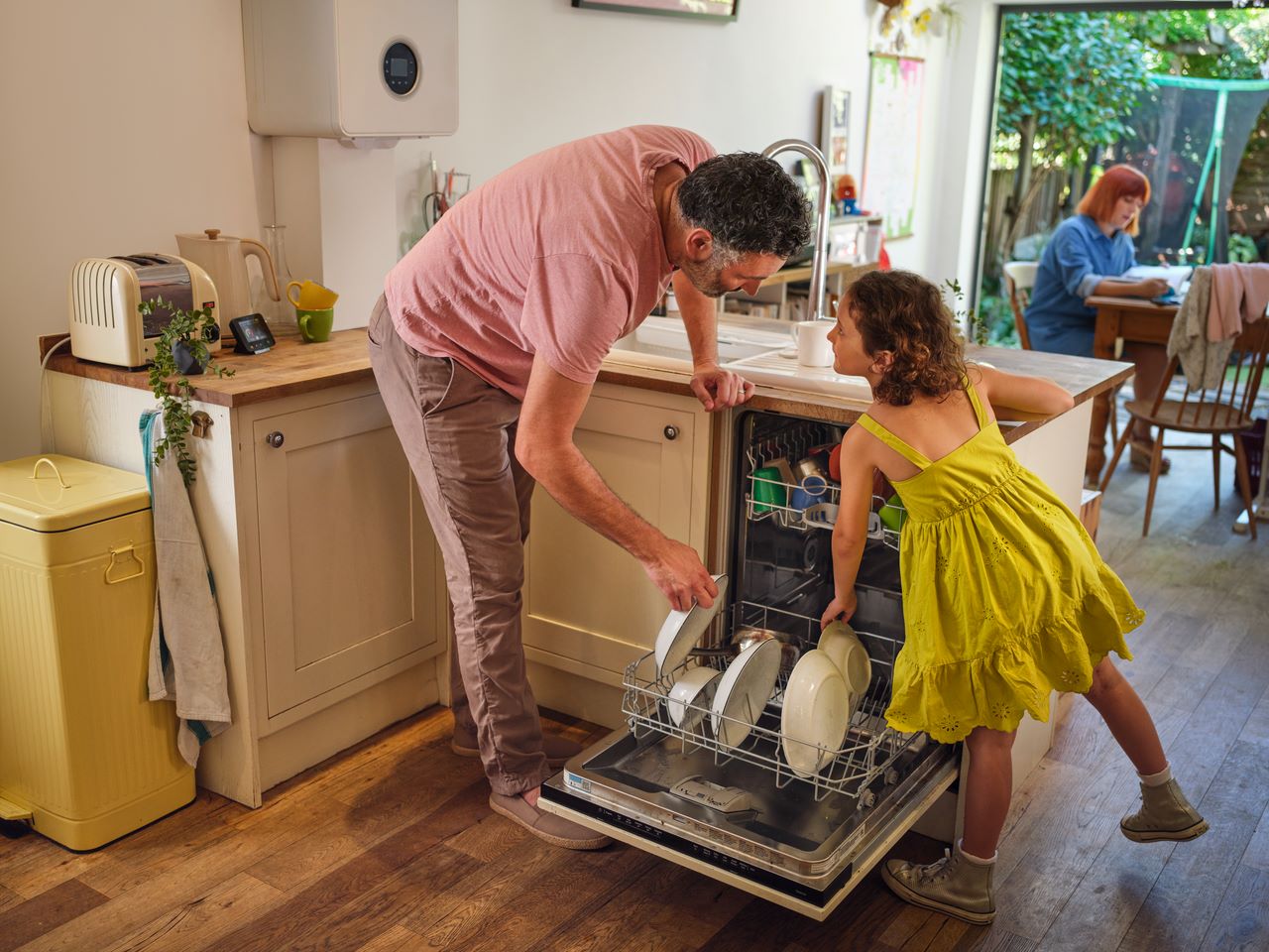 Father and daughter emptying dishwasher